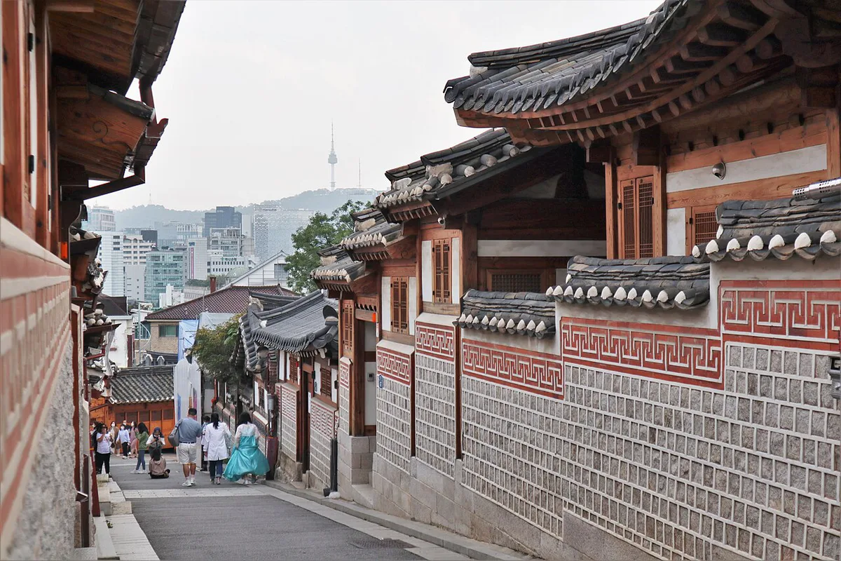 Traditional hanok rooftops along a steep alley in Bukchon Hanok Village — 1