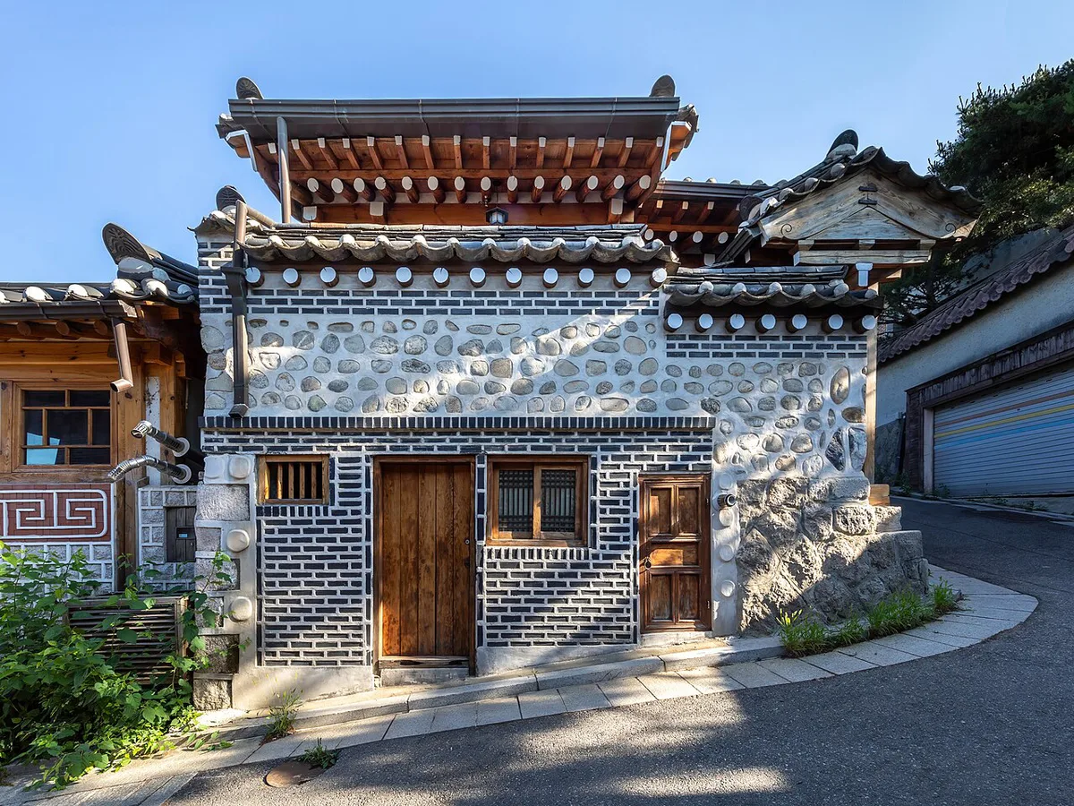 Traditional hanok rooftops along a steep alley in Bukchon Hanok Village — 2