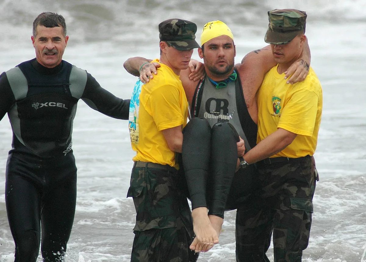 US Navy 050917-N-1577S-051 Basic Underwater Demolition-Sea Air and Land (SEAL) students help a physically challenged Superfrog Triathlon competitor out of the ocean during the 27th Annual Naval Special Warfare Superfrog Tria — 2